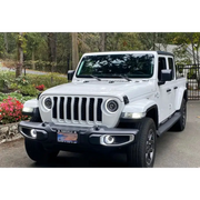 White Jeep Wrangler JK/JL/JT with LED fog lights parked in front of a house