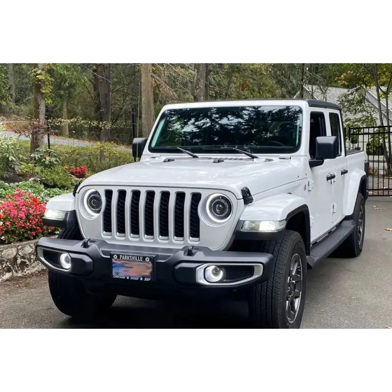 White Jeep Wrangler JK/JL/JT with LED fog lights parked in front of a house