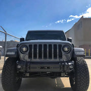 Oracle Jeep Wrangler LED Fog Lights parked in a lot with a fence