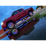 Red truck parked on dock with Oracle LED Illuminated Wheel Rings - ColorSHIFT Dynamic.