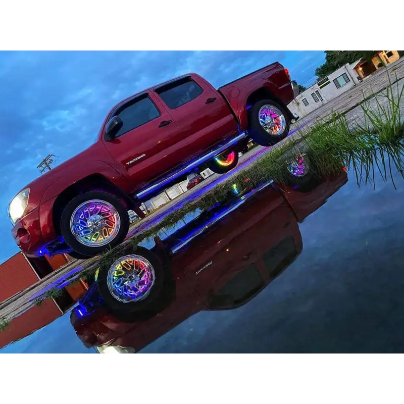 Red truck parked on dock with Oracle LED Illuminated Wheel Rings - ColorSHIFT Dynamic.