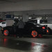 Oracle LED illuminated wheel rings kit in red with cars parked in a parking garage