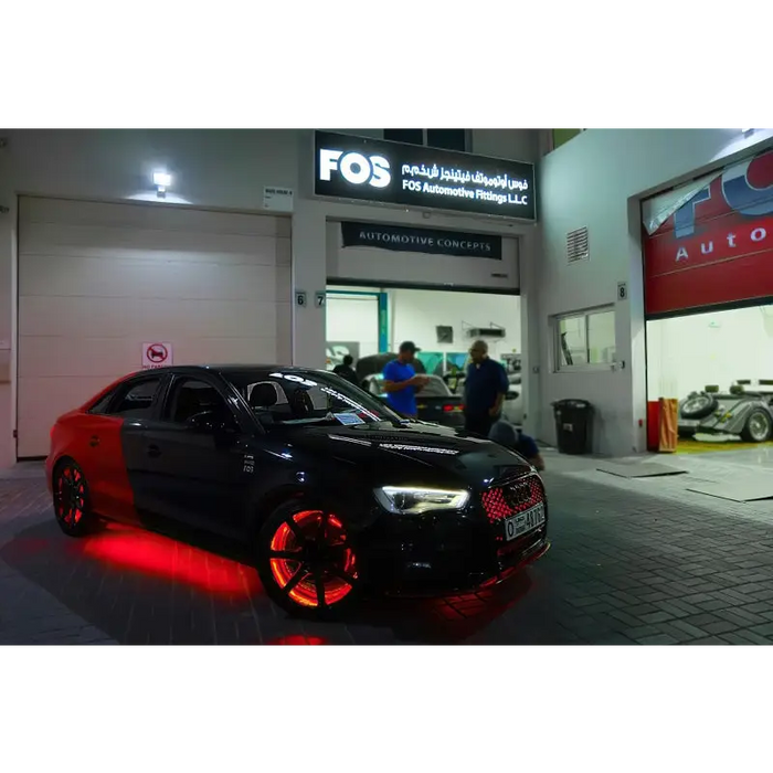 Red LED illuminated wheel rings kit with car parked in front of a building