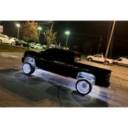 Black truck parked in parking lot with Oracle LED Wheel Rings - Double LED - White installed.