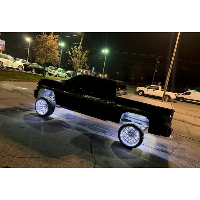 Black truck parked in parking lot with Oracle LED Wheel Rings - Double LED - White installed.