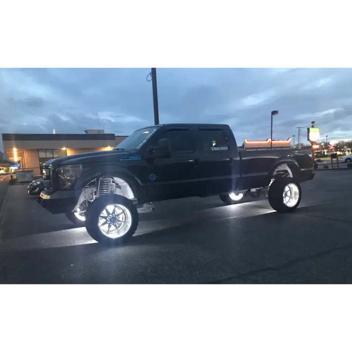 Black truck with a large tire fitted with Oracle LED Wheel Ring Kit - Double LED - White.