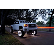 White LED illuminated wheel rings on truck parked on road - Oracle LED Wheel Ring Kit.