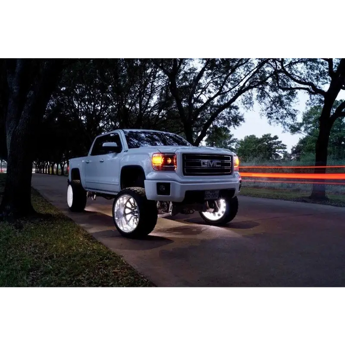 White LED illuminated wheel rings on truck parked on road - Oracle LED Wheel Ring Kit.