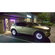 LED illuminated wheel rings kit with car parked in front of a building