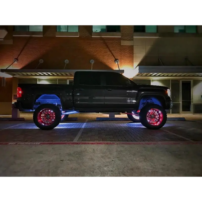 Black truck with red wheels parked in front of a building - Oracle LED Illuminated Wheel Rings - White.