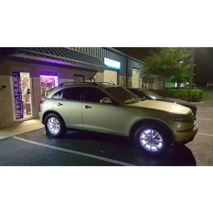 White Oracle LED illuminated wheel rings on car parked in front of building.