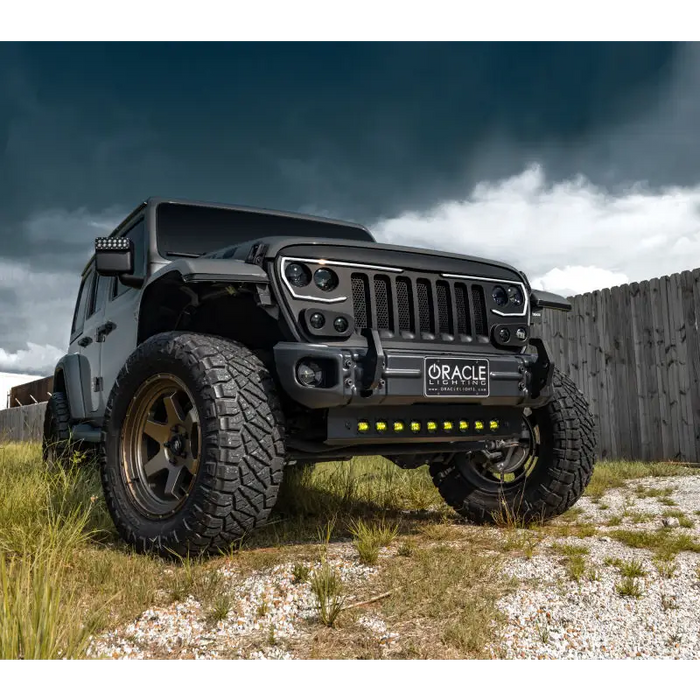 Yellow Jeep Wrangler JL parked in grassy field with skid plate - Oracle Lighting LED emitters.