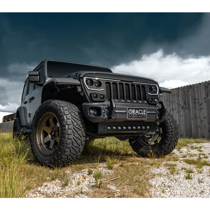 Jeep Wrangler JL parked in field with ORACLE Lighting skid plate and LED emitters.