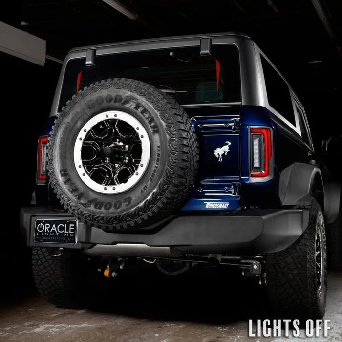 A black Ford Bronco with aftermarket LED taillights featuring a spare tire on the back