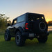 Black truck with Oracle Lighting 21-22 Ford Bronco Flush LED tail lights parked near a lake