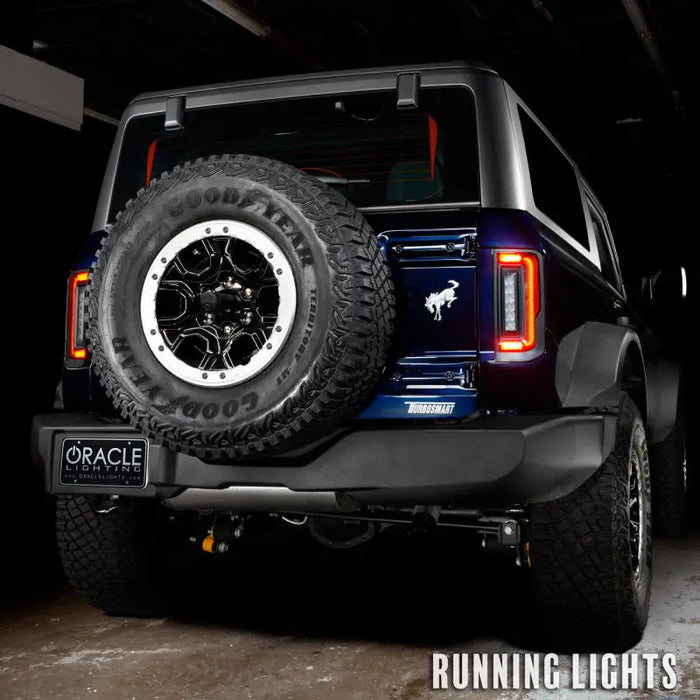 Black Jeep with large tire, Oracle Lighting LED tail lights for Ford Bronco.