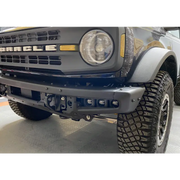 White Ford Bronco parked inside garage with ORACLE fog light kit installed