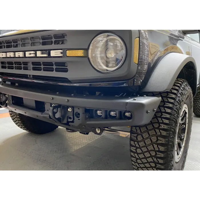 White Ford Bronco parked inside garage with ORACLE fog light kit installed