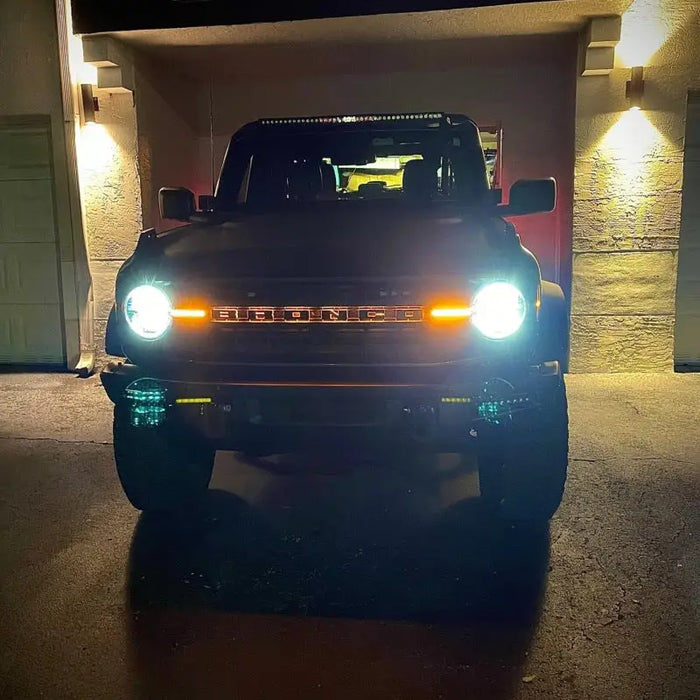 Truck with illuminated LED letter badges in garage.