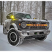 Truck driving through snow with LED letter badges.