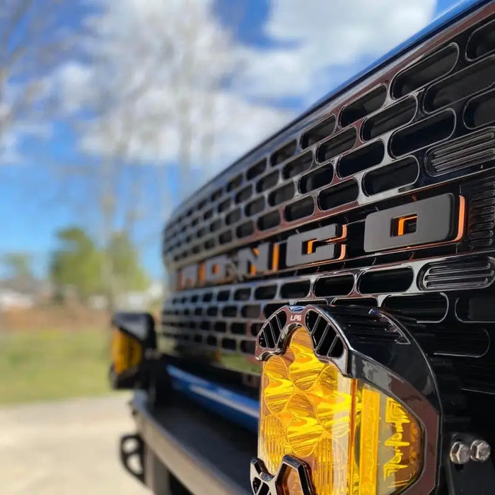 Close-up view of truck with yellow light and ORACLE Lighting Universal Illuminated LED Letter Badge - Matte Black Surface Finish - C