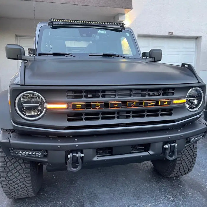 Black truck with LED letter badges illuminated by light.