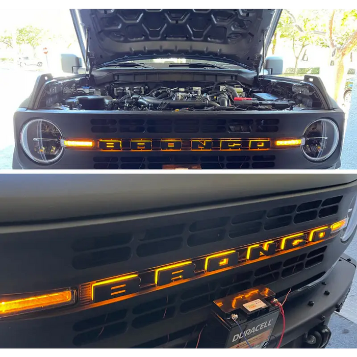 Matte black LED letter badges on front end of open hood black car.