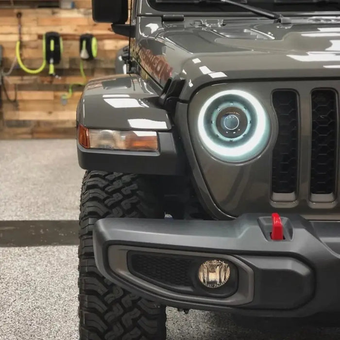 Oracle Oculus Bi-LED projector headlights for Jeep JL/Gladiator JT - graphite metallic with a light on its headlight.