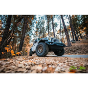Close-up of Jeep parked in woods on dirt road with Oracle Oculus Bi-LED Projector Headlights for Jeep JL/Gladiator JT - Matte Black - 550