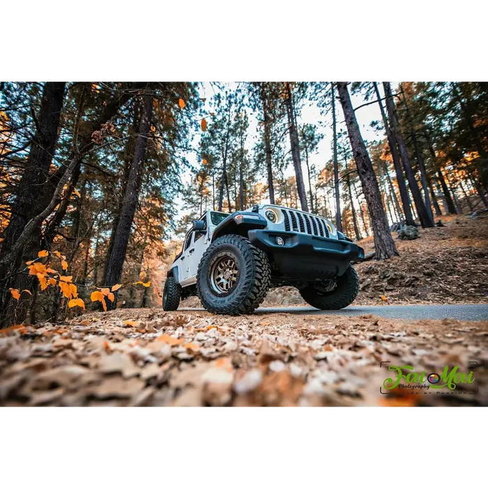 Close-up of Jeep parked in woods on dirt road with Oracle Oculus Bi-LED Projector Headlights for Jeep JL/Gladiator JT - Matte Black - 550