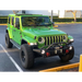 Green Jeep with Oracle Oculus Bi-LED Projector Headlights parked at yellow curb