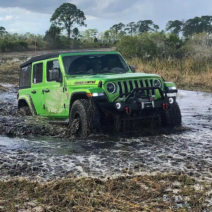 Green Jeep driving through muddy puddle with Oracle Oculus Bi-LED projector headlights.