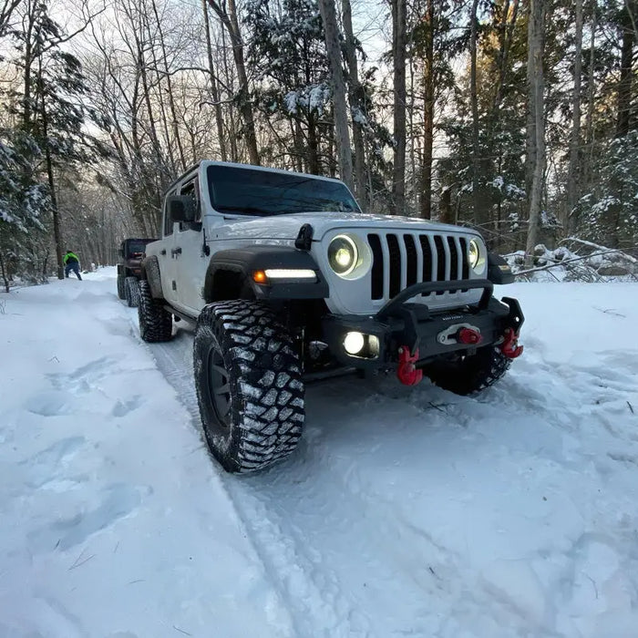 Oracle Oculus Bi-LED projector headlights for Jeep JL/Gladiator JT driving through snow-covered forest