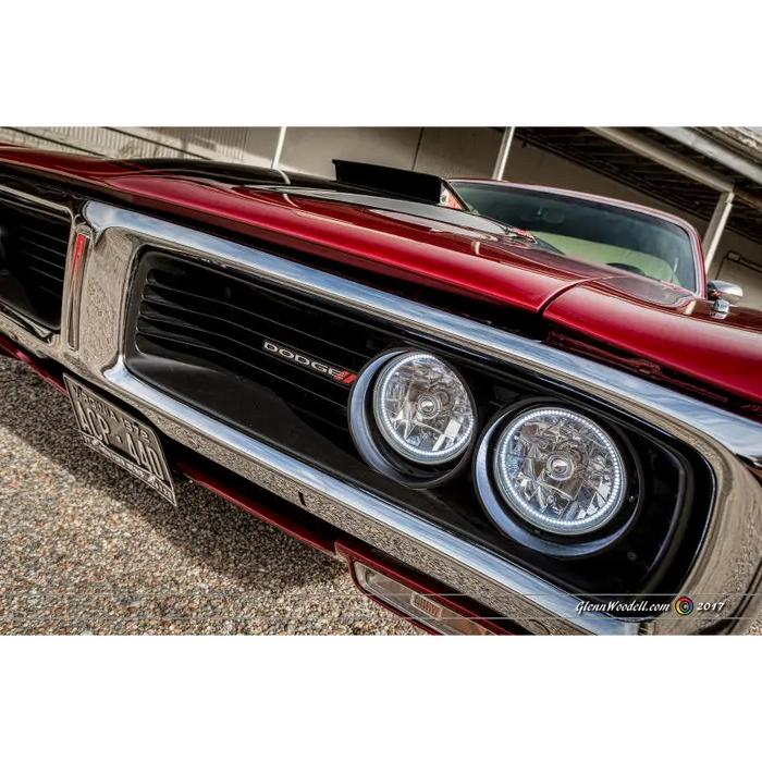 Red car with chrome headlights and rims featuring Oracle Pre-Installed ColorSHIFT sealed beam halo lights.