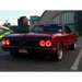 Red car parked in parking lot with Oracle Pre-Installed Lights sealed beam halo.