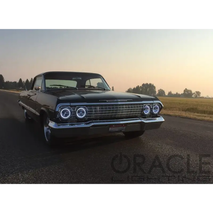 Black car parked on road with Oracle Pre-Installed Lights 5.75 IN. Sealed Beam - White Halo.