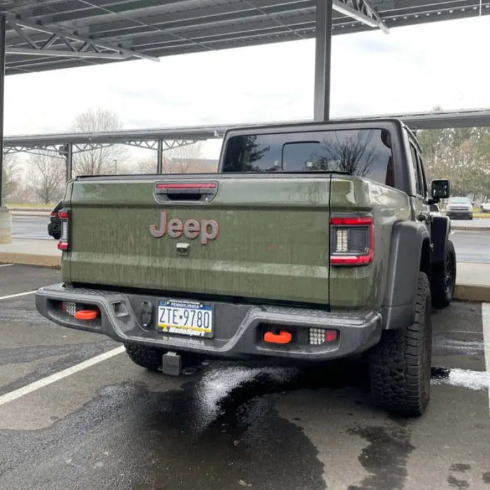 Green truck parked in a parking lot with Oracle Rear Bumper LED Reverse Lights for Jeep Gladiator JT.