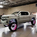 White rock lights truck with pink wheels and black rim - Oracle Underbody Wheel Well Rock Light Kit.