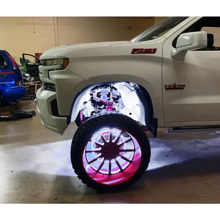 White truck with red wheels and rim illuminated by Oracle Underbody Wheel Well Rock Lights - White (4PCS) - 5000K