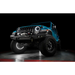 Close-up of blue Jeep illuminated by white rock lights against black background.