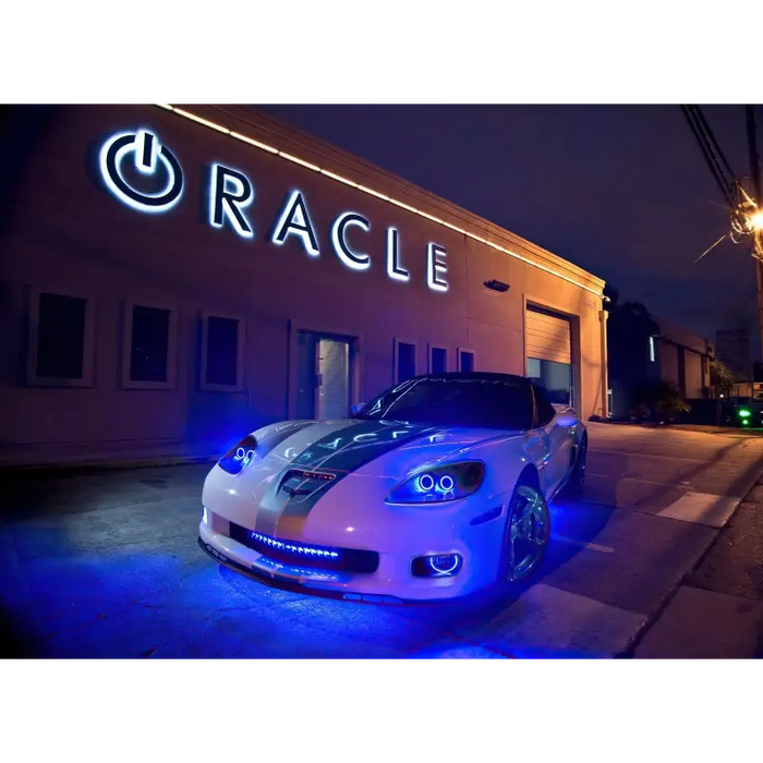 White car with Oracle Universal Dynamic LED Underbody Kit - ColorSHIFT - Dynamic parked in front of a building.