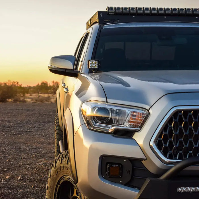 White Toyota Tacoma parked in desert with A-Pillar Light Mount Kit.