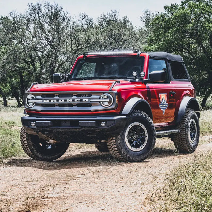 Red lifted truck parked on a dirt road with roof line mount kit for Ford Bronco.