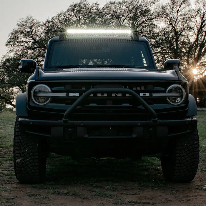 Black truck parked in field showcasing Rigid Industries roof rack light kit.