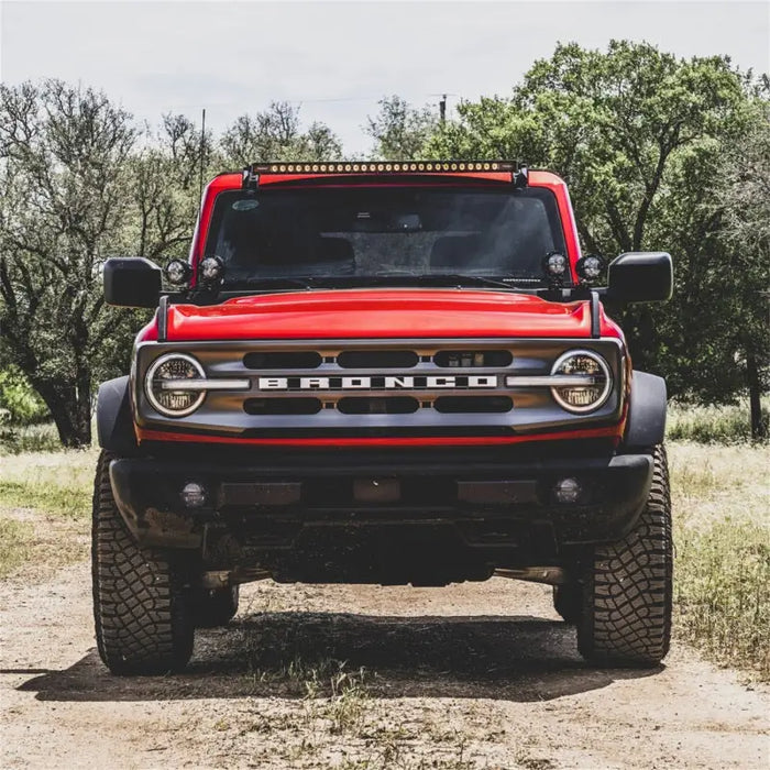 Red truck parked in the dirt near Rigid Industries fog light kit.