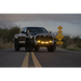 Rigid Industries 360-Series 4in Fog with Amber PRO Lens truck driving down road with sign in background.