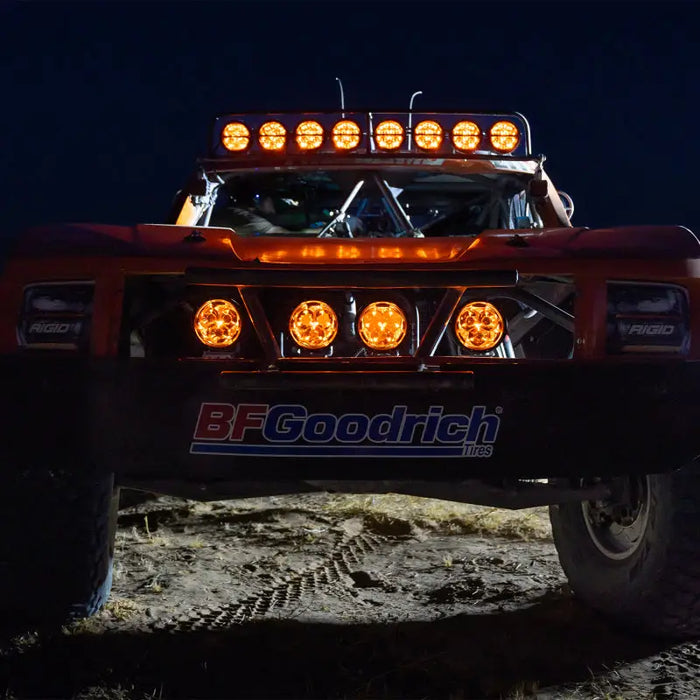 Red truck with headlights on illuminated by Rigid Industries 360-Series Laser Edition.