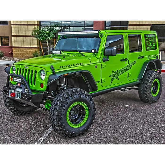 Green Jeep parked in lot with building in background, displayed with Rigid Industries Jeep JK A-Pillar Mount Kit - pillar mount kit.