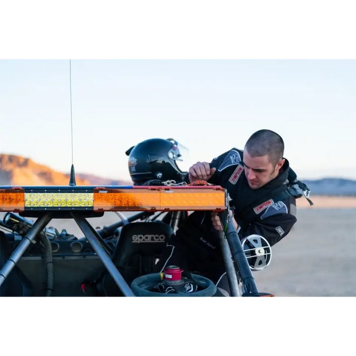 Man in black jacket working on motorcycle with Rigid Industries Light Cover for E/RDS Amber PRO - 10in.