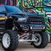 Black Dodge truck parked in front of graffiti wall with Radiance+ RGBW light bar.